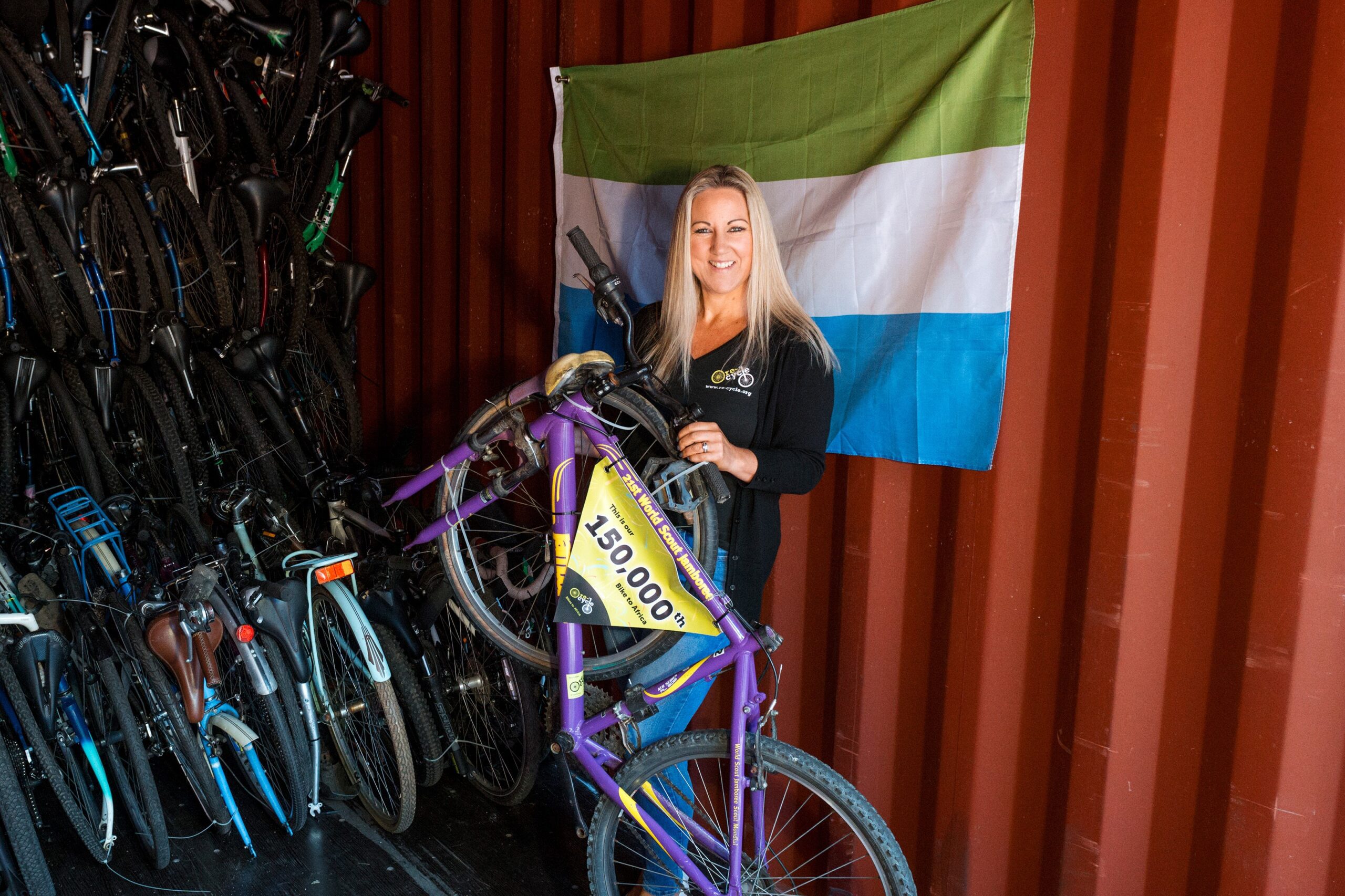 Director of Re-Cycle (Charlotte Ward) loading the 150,000th bike. Photo by Matt Grayson