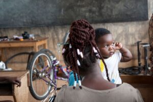 Lady with baby - Bicycle workshop Ghana