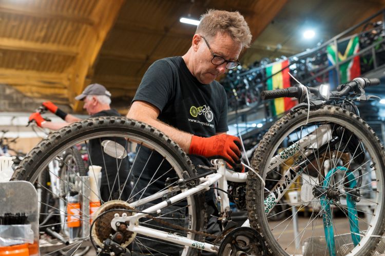 volunteer preparing bike in warehouse in essex