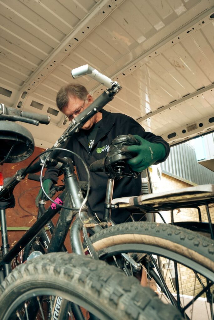 volunteer loading bikes into van collection